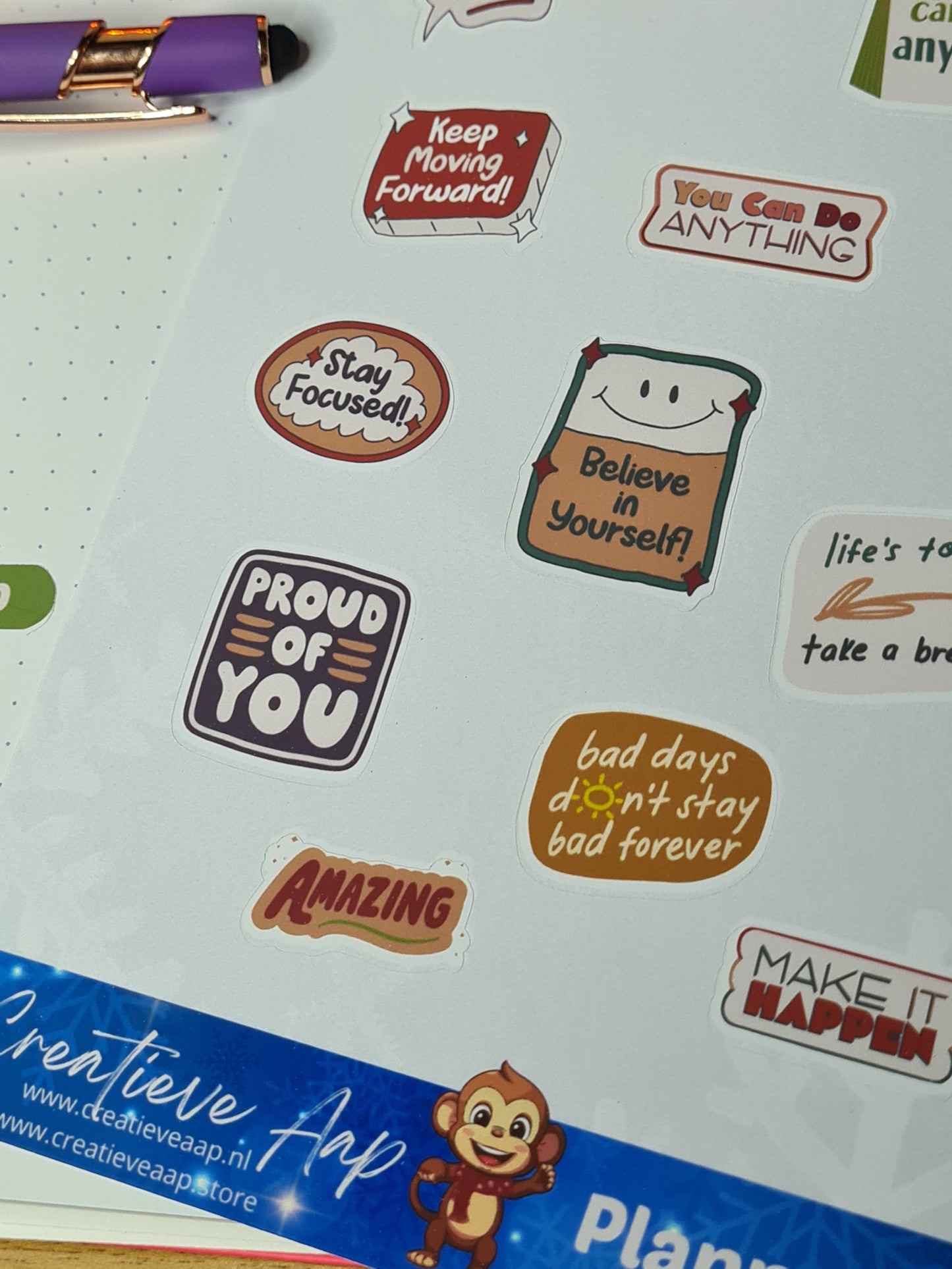 Detail van Positieve Quotes Planner Stickers met motiverende teksten zoals 'Proud of You' en 'Stay Focused' op een stickerblad.