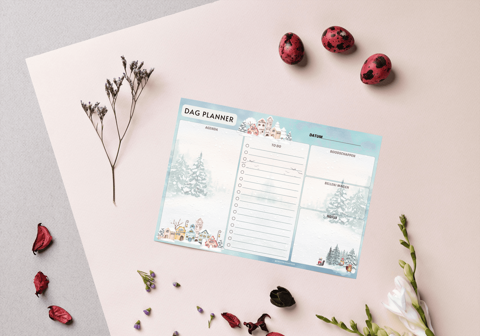 Dagplanner Winter 2025 – Handgemaakt Notitieblok met winters thema, liggend op een bureau met decoratieve bloemen en rode accenten. Perfect voor dagelijkse planning.