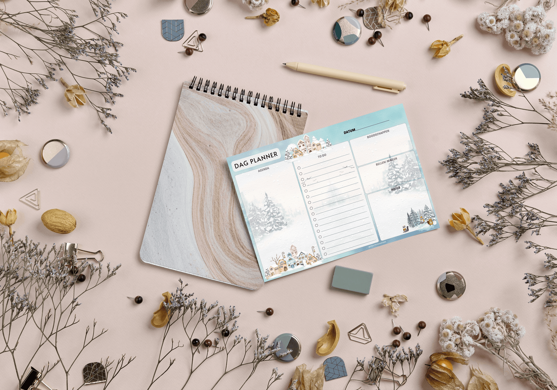 Dagplanner Winter 2025 – Handgemaakt notitieblok met winters thema, liggend op een beige achtergrond met decoratieve takjes en accessoires. Perfect voor dagelijkse planning.