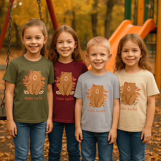Vier kinderen dragen het “Hallo Herfst Beer” kinder t-shirt in de kleuren Military Green, Maron, Sporty Grey en Sand. Herfstsetting met speeltuin – Creatieve Aap.