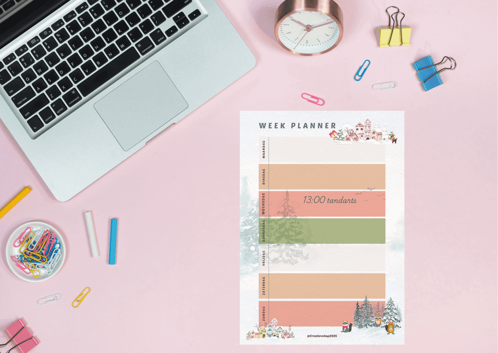 Weekplanner Winter 2025 in A4-formaat op een roze bureau met laptop, kleurrijke paperclips en een klassieke klok, perfect voor planning.